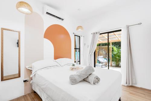 Dormitorio blanco con cama grande y espejo en Casa Sunshine y Palmeras en Matapalo