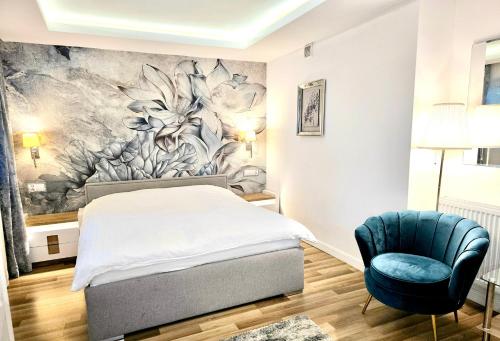 een slaapkamer met een bed en een blauwe stoel bij Sopot Spa Apartament in Sopot
