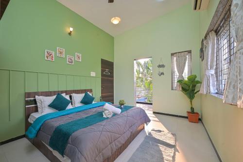 a bedroom with a bed with blue and green walls at Fortune Villa by Tropicana Stays in Lonavala