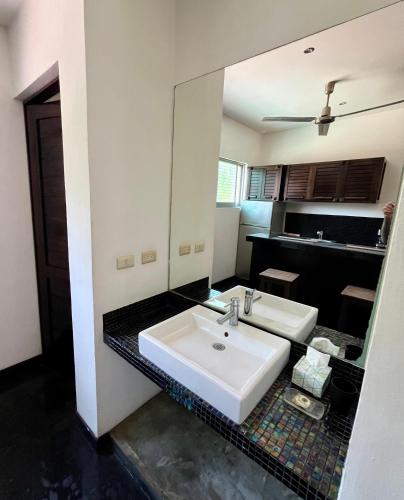 a bathroom with a white sink and a mirror at Hotel Aqualuna Departamento #aussiepipe in Puerto Escondido