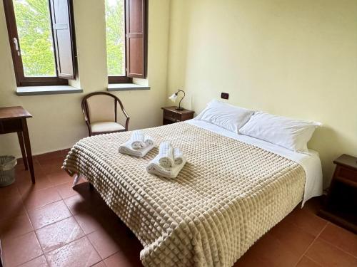 ein Schlafzimmer mit einem Bett mit zwei Handtüchern darauf in der Unterkunft NEBRIS - Rifugio del Parco in San Fratello