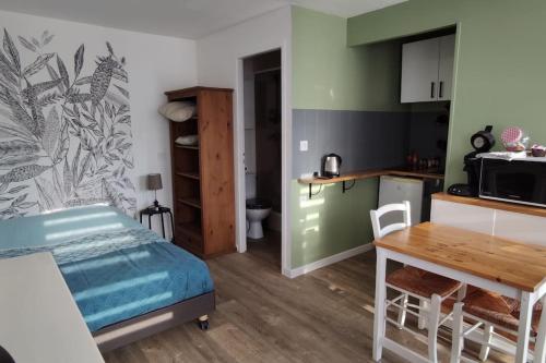 Cette chambre comprend un lit, une table et une cuisine. dans l'établissement Joli studio près de la mer avec extérieur, à La Rochelle