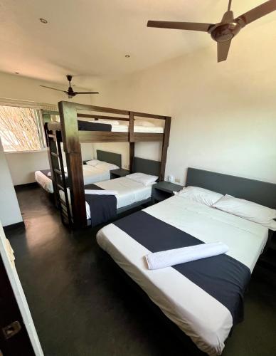 a bedroom with two beds and a ceiling fan at Hotel Aqualuna Departamento #aussiepipe in Puerto Escondido
