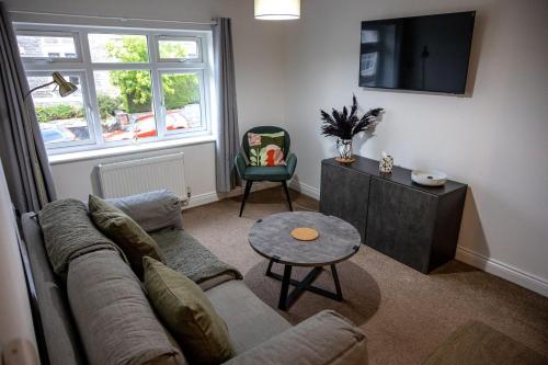 ein Wohnzimmer mit einem Sofa und einem Tisch in der Unterkunft Cozy 1-BR Sanctuary in Redland, Bristol in Bristol