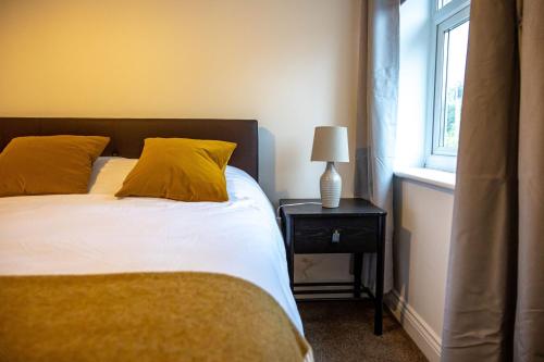a bedroom with a bed with yellow pillows and a window at Cozy 1-BR Sanctuary in Redland, Bristol in Bristol