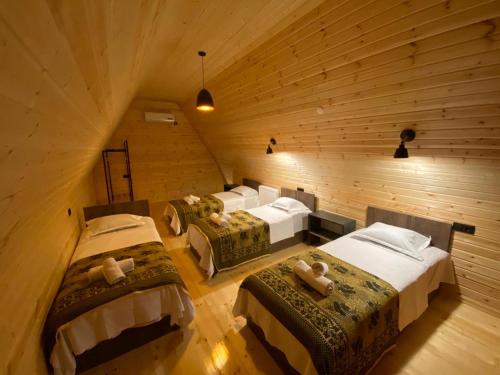 a attic bedroom with three beds in a room at Cottage Eco house in K'obulet'i