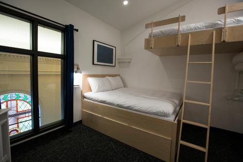 a bedroom with a bunk bed and a window at Le Saint-Crème in Alma
