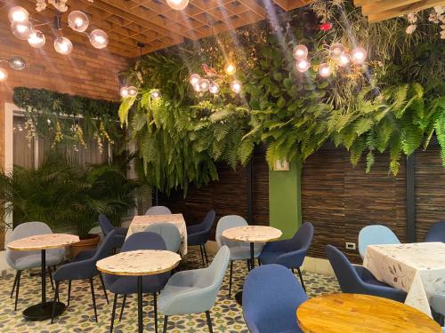 a room with tables and chairs and plants at Hotel Boutique Quinta Camacho in Bogotá