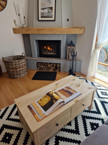 a coffee table in a living room with a fireplace at Cerdacul din Livada - Căsuța din Livadă in Vaideeni