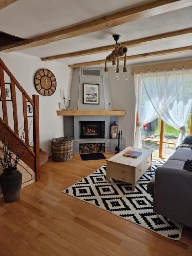 a living room with a couch and a fireplace at Cerdacul din Livada - Căsuța din Livadă in Vaideeni