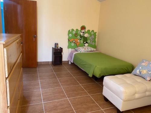 Habitación pequeña con cama y silla en Habitación cerca a los Pantanos de Villa, en Lima