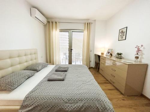 a bedroom with a large bed and a dresser at Currilave 664 in Durrës