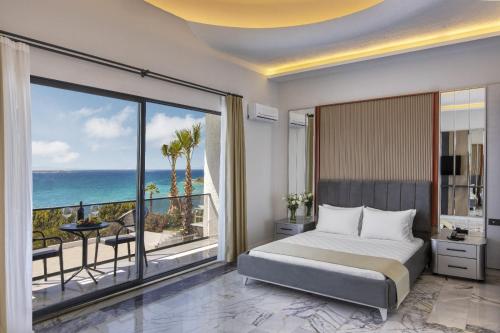 a bedroom with a bed and a view of the ocean at Sun Pearl Resort Çeşme in İzmir