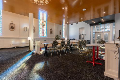 a room with tables and chairs and stained glass windows at Le Saint-Crème in Alma