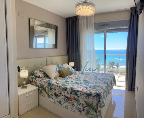 um quarto com uma cama e vista para o oceano em Magic View - Esquinero frontal mar Marina d'Or em Oropesa del Mar