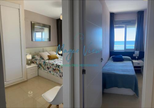um quarto com uma cama, uma secretária e uma janela em Magic View - Esquinero frontal mar Marina d'Or em Oropesa del Mar