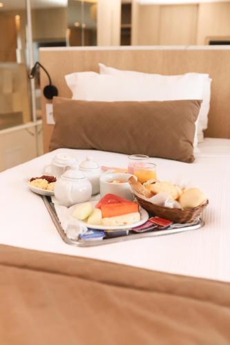 een dienblad met eten op een bed bij Marano Hotel in Salvador