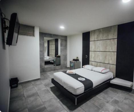 a bedroom with a large bed and a bathroom at Hotel Panorama Center in Medellín
