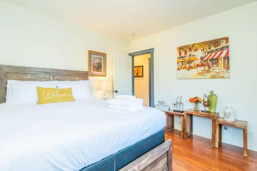 Un dormitorio con una gran cama blanca y una mesa en Newly Remodeled 3B2B House, en Glendora