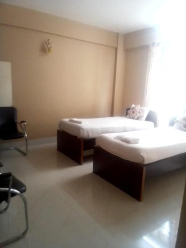 dwa łóżka w pokoju z oknem w obiekcie Field Residency Inn w mieście Shillong