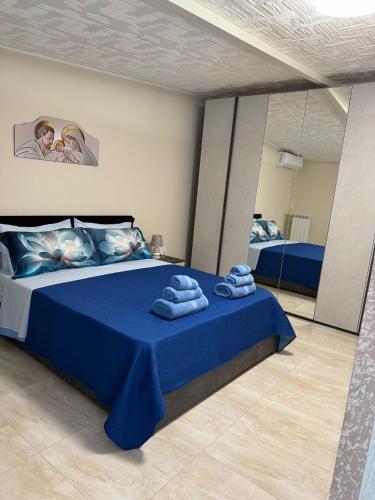um quarto com uma cama azul com toalhas em Casetta in villa indipendente em Angri