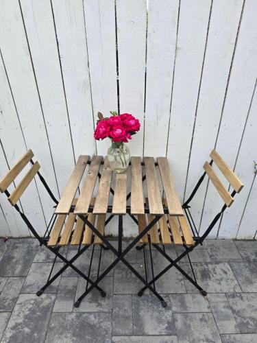 a wooden picnic table with a vase of flowers on it at Beautiful Basement Suite & Outdoor Oasis in Washington, D.C.