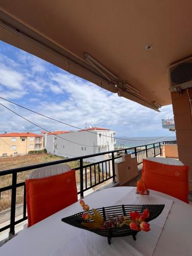 una mesa con un bol de fruta en el balcón con vistas al océano en Ocean View Apartments, en Vrasná