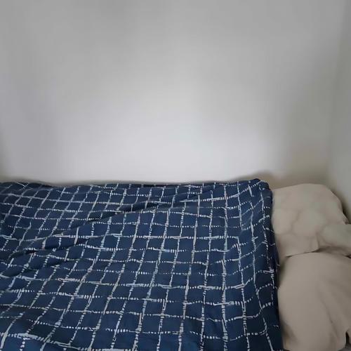 Una cama con una almohada azul y blanca. en Fully Furnished Modern Apartment en Sollentuna