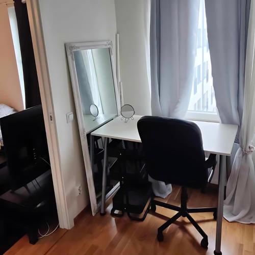 Habitación con escritorio con espejo y silla. en Fully Furnished Modern Apartment en Sollentuna