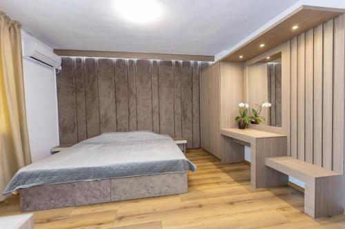 a bedroom with a bed and a wooden floor at Family Hotel Ambrozia in Sandanski