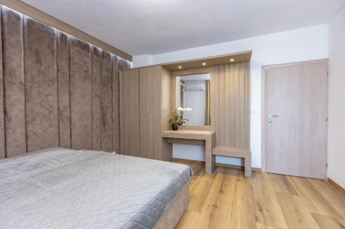 a bedroom with a bed and a table and a mirror at Family Hotel Ambrozia in Sandanski