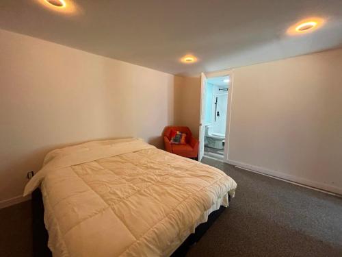 a bedroom with a bed and a chair in it at Waterfront Lakehouse Getaway in Clinton with HOT TUB in Clinton