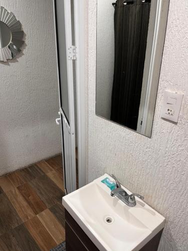 a bathroom with a sink and a mirror at Departamentos 1 min Plaza las Américas in Morelia