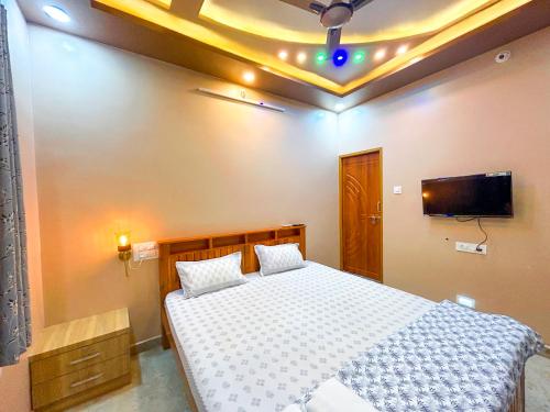 a bedroom with a bed and a tv on the ceiling at JFZ Homestay in Honāvar