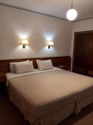 a bedroom with a large white bed with two lights at Hotel Riogrande in Santa Fe