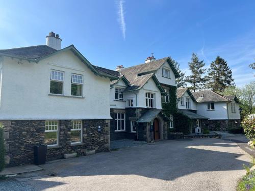 a large white house with a driveway at The Ryebeck Hotel in Bowness-on-Windermere