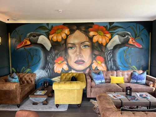 a living room with a painting of a woman at The Ryebeck Hotel in Bowness-on-Windermere