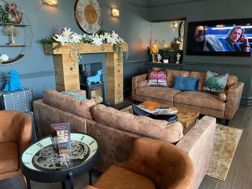 a living room with two couches and a tv at The Ryebeck Hotel in Bowness-on-Windermere