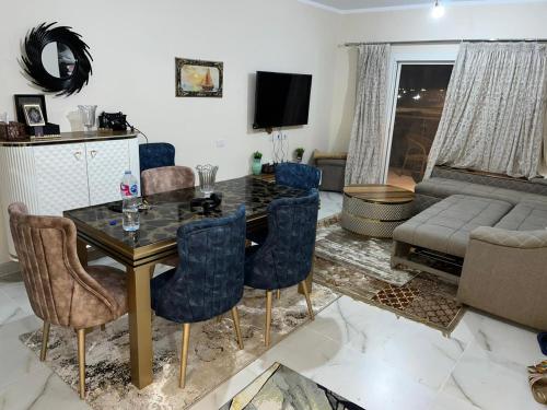 sala de estar con mesa, sillas y sofá en داون تاون العلمين الجديدة en ‘Ezbet `Abd el-Ḥamîd