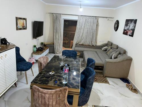sala de estar con mesa y sofá en داون تاون العلمين الجديدة en ‘Ezbet `Abd el-Ḥamîd