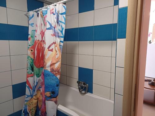 uma cortina de chuveiro numa casa de banho com azulejos azuis e brancos em ZafireniaSuites em Elevtheraí