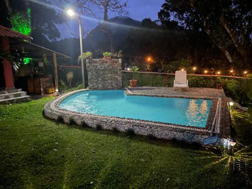a swimming pool in a yard at night at Hostal La India in Valle de Anton