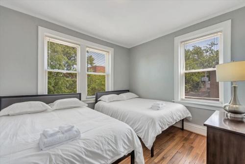 two beds in a room with two windows at 2e Tower Grove Getaway in Richmond Heights