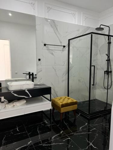 baño blanco y negro con ducha y taburete en Lux в ЖК TALAN LIFE от Bi Group, en Atyraū