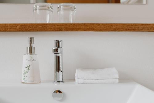 a white counter with a bottle of soap and towels at Hotel Berghaus Rosengarten in Nova Levante