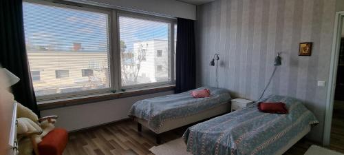 a bedroom with two beds and a large window at "Jääskeläinen", Pieksämäen sydämessä in Pieksamaki
