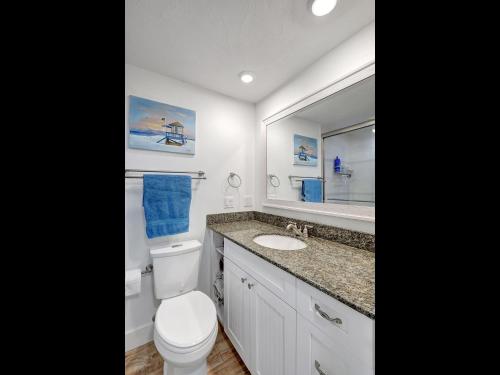 a bathroom with a toilet and a sink and a mirror at 1166 PD Contemporary Coastal Luxury in Siesta Key