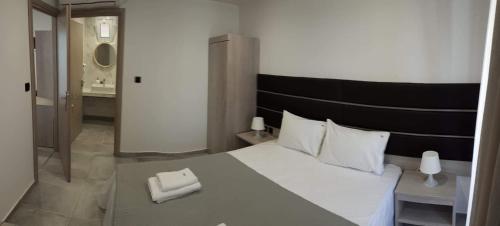 a bedroom with a white bed with a black headboard at THALASSA BOUTIQUE HOTEL in Sarti