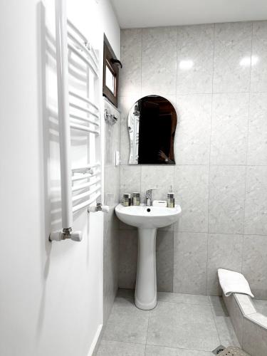 a white bathroom with a sink and a mirror at Villa Achkhoti (Kazbegi) in Kazbegi