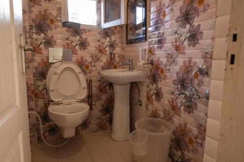 La salle de bains est pourvue de toilettes et d'un lavabo. dans l'établissement Dew Drops Homestay, à Nainital